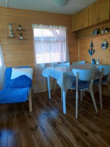 a dining room with a white table and chairs at Domus Mare domek holenderski in Wisełka +22 photos