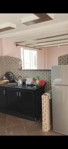 a kitchen with a black counter and a refrigerator at Isila blanca in Sidi Bouzid