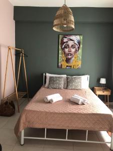 Artemis Apartments في دياكوبتو: غرفة نوم بسرير مع صورة لامرأة