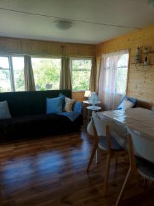 a living room with a black couch and a table at Domus Mare domek holenderski in Wisełka
