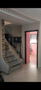 una escalera en una casa con una puerta roja en Isila blanca, en Sidi Bouzid