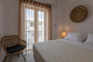 sypialnia z łóżkiem, krzesłem i oknem w obiekcie Suites 33 w mieście Kos