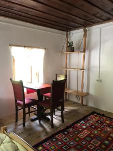 ein Esszimmer mit einem Tisch, Stühlen und einem Fenster in der Unterkunft Guesthouse Kujtimi in Theth