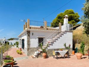 een wit huis met een trap en een tafel bij En-suite bedroom with private entrance at Casa Sofija in Sedella