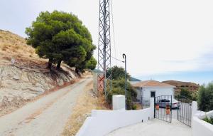 un camino de tierra con un árbol a un lado de una colina en En-suite bedroom with private entrance at Casa Sofija, en Sedella