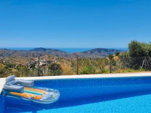 een zwembad met een opblaasbaar vlot in het water bij En-suite bedroom with private entrance at Casa Sofija in Sedella