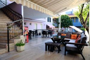 a patio with a couch and a table and chairs at Opalin Otel in Kemer