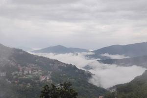 a view of a mountain with clouds in the valley at Shiloh Khim in Gangtok