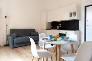 designer apartment via nazionale في روما: غرفة معيشة مع طاولة وكراسي وأريكة