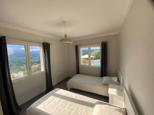 a small bedroom with two beds and two windows at villa du Passeron in Chambonas +49 photos