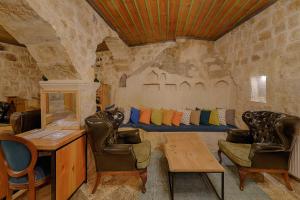 a living room with two chairs and a couch at Taru Cave Suites in Urgup