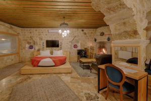 a bedroom with a bed and a tv in a room at Taru Cave Suites in Urgup