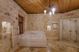 a large bathroom with a tub and a shower at Taru Cave Suites in Urgup
