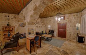 a room with a stone wall with a table and chairs at Taru Cave Suites in Urgup
