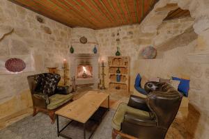 a living room with chairs and a table and a fireplace at Taru Cave Suites in Urgup