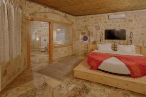 a bedroom with a bed and a television in a room at Taru Cave Suites in Urgup