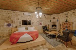 a bedroom with a bed and a stone wall at Taru Cave Suites in Urgup