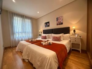 a bedroom with two beds and a desk and a bed at CLAREN'S GUESTHOUSE in Cangas del Narcea