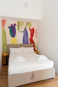 designer apartment via nazionale في روما: سرير أبيض في غرفة بها لوحة على الحائط
