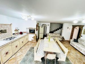 cocina y sala de estar con mesa y sofá en Maria Antonietta House, en Porto Torres