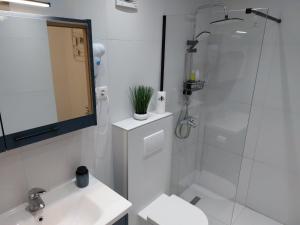 a white bathroom with a shower and a sink at Apartment AB Batala in Dubrovnik