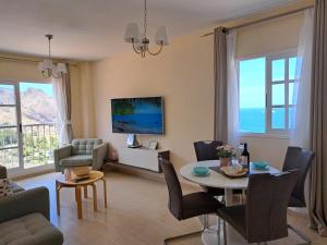 San Andres Beach View Apartment في San Andrés: غرفة معيشة مع طاولة وكراسي