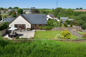 a white house with a patio and a yard at The Garden Apartment a luxurious Rural Retreat in Wellington