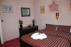 Schlafzimmer mit einem Bett mit einer roten und weißen Bettdecke in der Unterkunft Ambassy Hotel in Kenitra