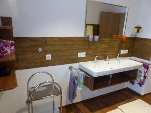 ein Bad mit einem Waschbecken und einem Spiegel in der Unterkunft Allgäuer Landhaus Stocker in Hopferau