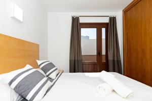 a bedroom with a white bed with black and white pillows at Casita di Mare First line By PVL in Punta de Mujeres