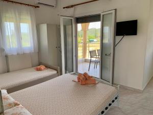 two beds in a room with a balcony at Nikolaidis House in Sykia Chalkidikis