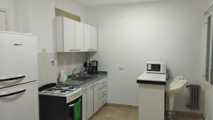 cocina con armarios blancos y fogones en Amplio departamento 3 amb en muy buena ubicación en Buenos Aires