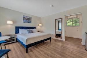 a bedroom with a large bed and a table and chairs at Endless Dunes, A Modern Motel in Eastham