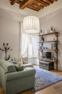 a living room with a couch and a chandelier at Stence Apartment in Lucca