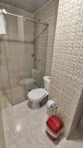 a bathroom with a toilet and a glass shower at Edificio GrandSky in Cali