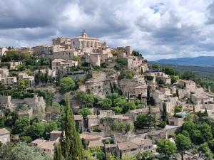 a village on top of a hill with houses at La perle de Gordes in Gordes