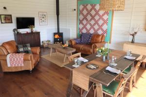 a living room with couches and tables and a fireplace at Pavilion in Llantwit Major