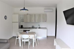 una cucina con un tavolo e sedie in una stanza di Verde Blu Vacanze Suites a Porto Cesareo
