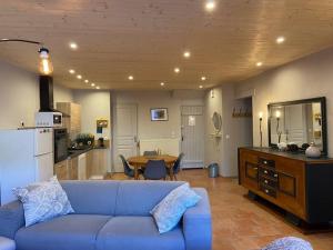 a living room with a blue couch and a kitchen at Le petit Luxembourg in Valleraugue