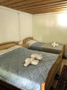 2 Betten in einem Zimmer mit Handtüchern auf einem Bett in der Unterkunft Guesthouse Kujtimi in Theth