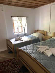 1 dormitorio con 2 camas y ventana en Guesthouse Kujtimi, en Theth