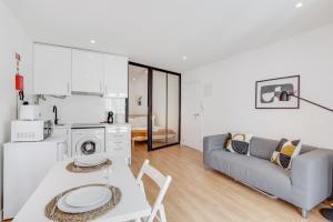 a kitchen and living room with a table and a couch at Hygge Chiado in Lisbon