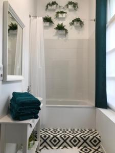 La salle de bains est pourvue d'une douche et d'une baignoire blanche. dans l'établissement Aux Remparts de Montreuil, à Montreuil-sur-Mer