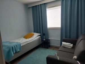 1 dormitorio con cama, sofá y ventana en Ristimäenkatu en Mikkeli