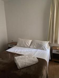 1 dormitorio con 1 cama con sábanas y almohadas blancas en Apart Alameda Santos - Paulista, en São Paulo