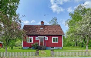 una casa roja con una valla blanca en Beautiful Home In Vrigstad With Kitchen en Vrigstad