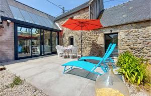 eine Terrasse mit einem blauen Stuhl und einem Sonnenschirm in der Unterkunft Stunning Home In Plouguerneau With Kitchen in Plouguerneau