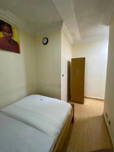 sypialnia z łóżkiem i zegarem na ścianie w obiekcie Apartment D (Deluxe One Bedroom Apartment) w mieście Lagos