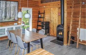een eetkamer met een tafel en een houtkachel bij Beautiful Home In Skillingaryd With 3 Bedrooms And Wifi in Skillingaryd