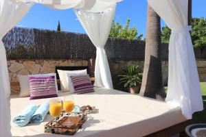 a white canopy bed with two glasses of orange juice at Villa los Tablazos SpainSunRentals 1009 in Frigiliana